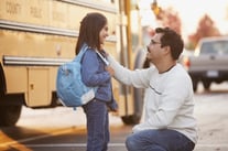 father-saying-goodbye-to-daughter-in-front-of-school-bus-1